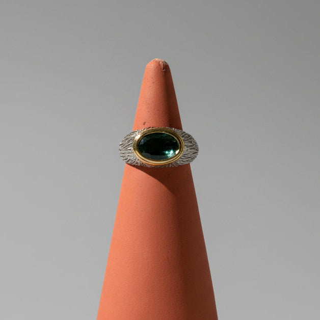 One of one green tourmaline east west bezel ring with brass accents and tree trunk band detailing by Kismet Society — size 6.5