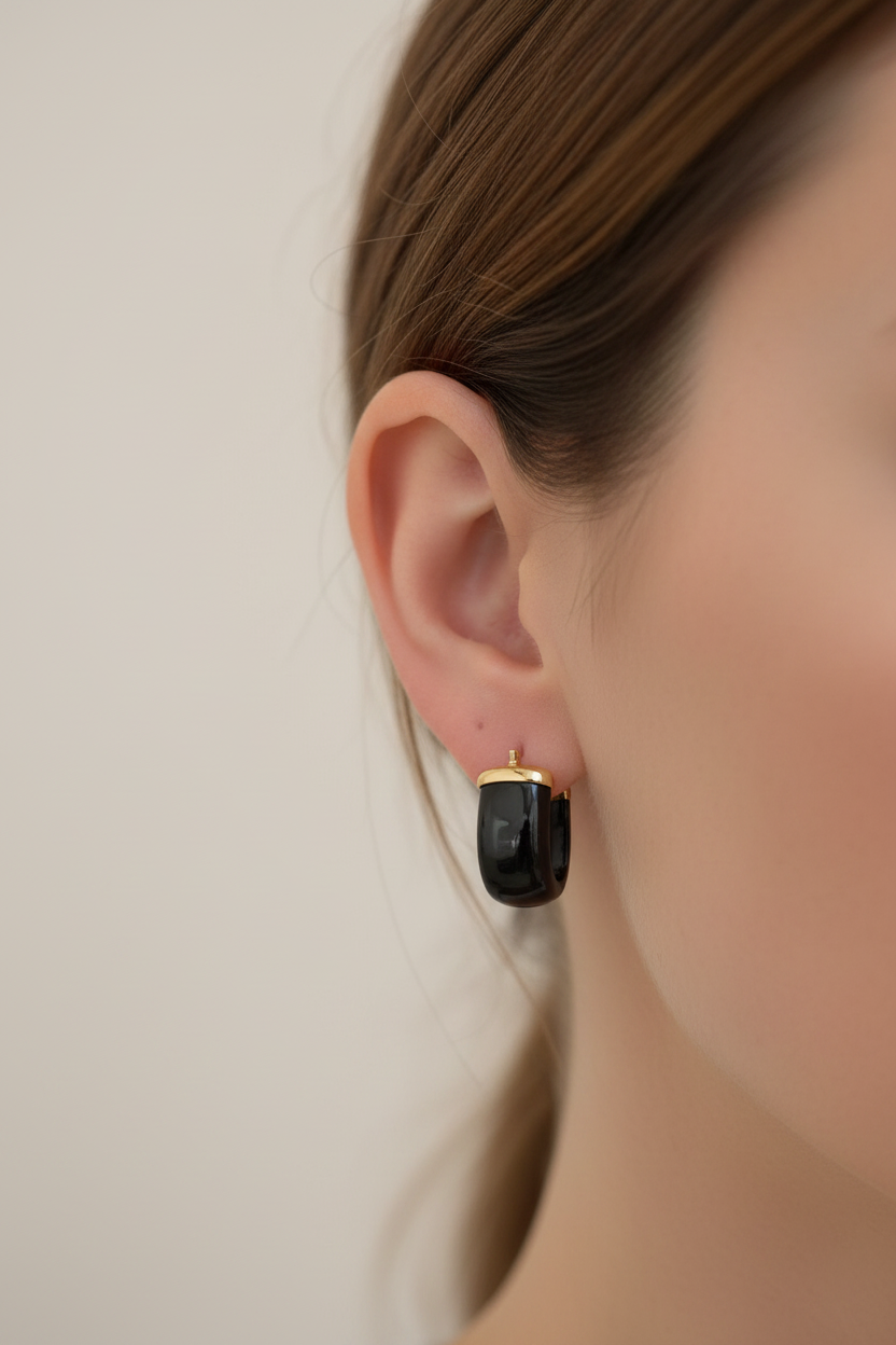 Close up of The Noir chunky black onyx hoop earring worn on model, white studio background, Kismet Society fine jewelry